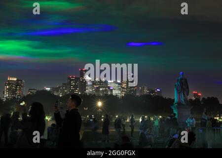 Greenwich, London, Großbritannien. August 2021. Die Menschen beobachten das Spektakel. An seiner offiziellen öffentlichen Startnacht beleuchtet „Borealis“ von Dan Archer den Himmel über dem Old Royal Naval College im Royal Borough of Greenwich. „Borealis“ ist eine faszinierende Nachbildung der Nordlichter am Himmel. Es ist Teil des jährlichen Greenwich and Docklands Festivals, das vom 27. August bis 11. September 2021 stattfindet. Kredit: Imageplotter/Alamy Live Nachrichten Stockfoto