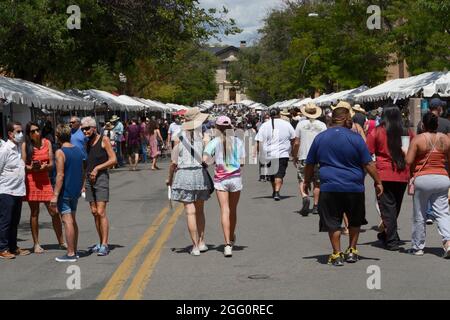 Auf dem jährlichen Santa Fe Indian Market in New Mexico, auf dem Hunderte von einheimischen Künstlern vertreten sind, füllen Besucher eine Straße mit Kunstständen der Ureinwohner Amerikas. Stockfoto