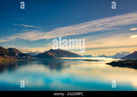 Atemberaubende Panoramaaussicht auf die südlichen Alpen und die Bergreflexionen auf dem sehr ruhigen stillen Wasser des Lake Wakatipu Stockfoto