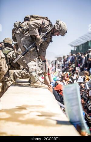 Ein Marine mit Special Purpose Marine Air-Ground Task Force-Crisis Response-Central Command (SPMAKTF-CR-CC) hebt während einer Evakuierung am Hamid Karzai International Airport, Kabul, Afghanistan, am 26. August eine Evakuierung auf. US-Dienstmitglieder unterstützen das Außenministerium bei einer geordneten Abseichung von designiertem Personal in Afghanistan. (USA Marine Corps Foto von Sgt. Samuel Ruiz). Stockfoto