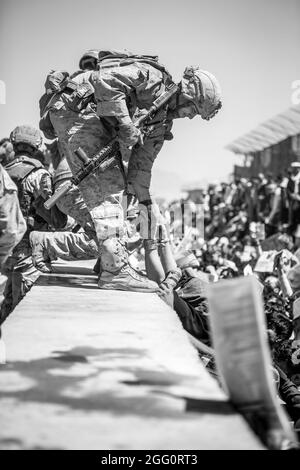 Ein Marine mit Special Purpose Marine Air-Ground Task Force-Crisis Response-Central Command (SPMAKTF-CR-CC) hebt während einer Evakuierung am Hamid Karzai International Airport, Kabul, Afghanistan, am 26. August eine Evakuierung auf. US-Dienstmitglieder unterstützen das Außenministerium bei einer geordneten Abseichung von designiertem Personal in Afghanistan. (USA Marine Corps Foto von Sgt. Samuel Ruiz). Stockfoto