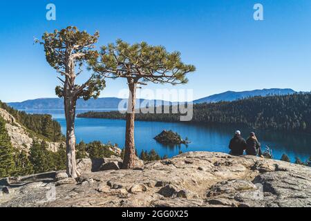 Zwei Personen sitzen auf Felsen mit Blick auf Emerald Bay, Lake Tahoe, Kalifornien Stockfoto