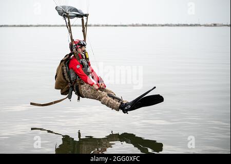 US Air Force Tech. Sgt. Michael Galindo, Leiter der 38. Abteilung des Rettungsgeschwaders Blue Team, bereitet sich darauf vor, während des Wassersprungtrainings in der Nähe der Patrick Space Force Base, Florida, am 24. August 2021 im Banana River zu landen. Das Training wurde entwickelt, um Pararescuemen für die Unterstützung des SpaceX-Programms für die Raumfahrt und des Raumfahrtprogramms von Boeing vorzubereiten. Im Falle eines Raketenabschussfehlers kann sich die Kapsel der Rakete von der Rakete lösen und im Ozean landen. Die 38. RQS würde dann Wassersprünge durchführen, nachdem sie Kampffluggummi-Raidfahrzeuge fallen ließen, die sie dann zur Aufnahme verwenden würden Stockfoto