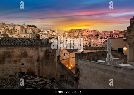 Ein farbenfroher Sonnenuntergang über den alten sassi und Wohnungen in der Stadt Miera, Italien, in der Region Basilicata. Stockfoto