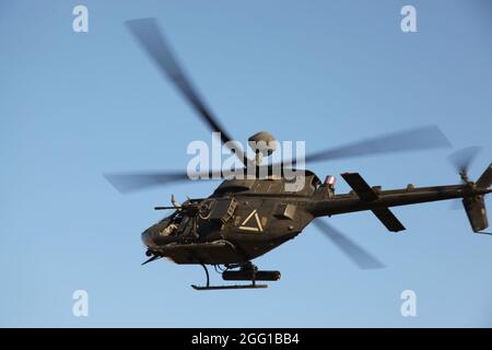 Ein US-Armeepilot eines OH-58-Kriegers aus der Kiowa winkt den Truppen am Boden zu, während er während der Einsätze im Sherzad District, Nangarhar Province, Afghanistan, am 27. Dezember 2010 Luftunterstützung leistet. (USA Armee-Foto von SPC. Andy Barrera) Stockfoto