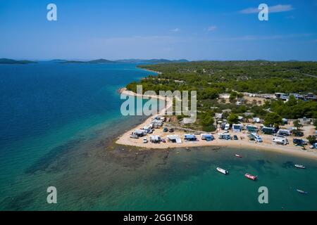 Luftaufnahme mit Drohne. Kristallklares Meer mit schönem Strand in Kroatien. Camping. Einige Motorboote. Stockfoto