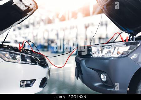 Limousine überbrücken die Batteriekabel zum Pickup-Truck in der Reparaturwerkstatt Stockfoto