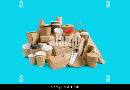 Viele verschiedene Lebensmittelbehälter zum Mitnehmen, Pizzaschachteln, Kaffeetassen im Halter und Pappschachteln auf blauem Hintergrund. Stockfoto