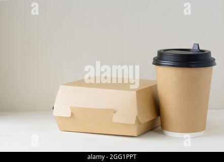 Kaffeetasse aus Papier und Lebensmittelbox auf dem Tisch Stockfoto