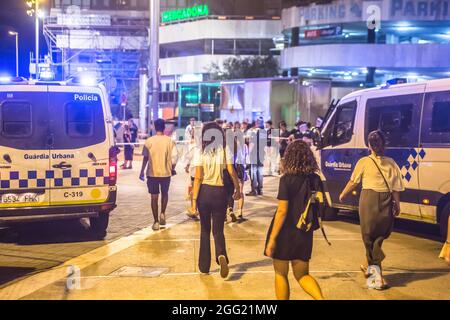 Barcelona, Spanien. August 2021. Man sieht, wie Menschen den Park neben Polizeiwagen verlassen.das traditionelle Fest "Festa Major de Sants" des Stadtteils Sants in Barcelona, eine riesige Menschenmenge, die im Hauptpark des Stadtteils, dem Parque de la España Industrial (Park of Industrial Spain), trank, Danach verdrängte die Polizei die Menge aus dem Park. Kredit: SOPA Images Limited/Alamy Live Nachrichten Stockfoto