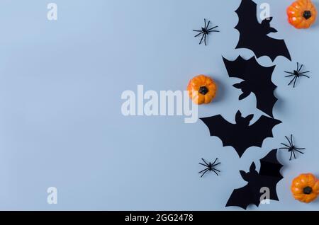 Dekorative festliche Hintergrund Halloween. Papierdekor, Fledermäuse, Spinnen, Kürbisse auf blauem Hintergrund. Kopierbereich, flaches Layout Stockfoto