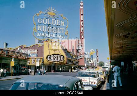 Das Golden Nugget Casino, mit dem Lucky Casino dahinter, Fremont Street, Las Vegas, Nevada, USA im Jahr 1963. Unter allen Neon-Schildern steht ein Schild für eine Live-Performance von Willie Nelson (Mitte links). Das Golden Nugget wurde ursprünglich 1946 erbaut und ist damit eines der ältesten Casinos der Stadt – ein altes Foto aus den 1960er Jahren. Stockfoto