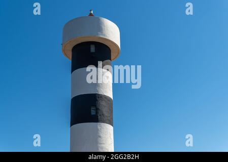 Nahaufnahme des Leuchtturms der Stadt Colonia de Sant Jordi auf der Insel Mallorca mit dem blauen Himmel im Hintergrund Stockfoto