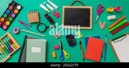 Schule liefert flach legen. Schreibwaren auf grünem Hintergrund, Draufsicht. Bildung, Back to School, Kinder Kreativität Konzept Stockfoto