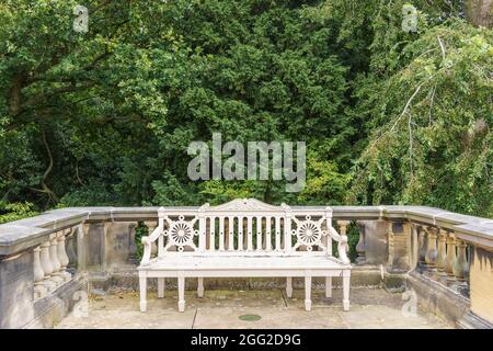 Vintage hölzerne Gartenbank mit komplizierten Schnitzereien auf der Rückseite Ruhe im üppigen grünen Park. Stockfoto