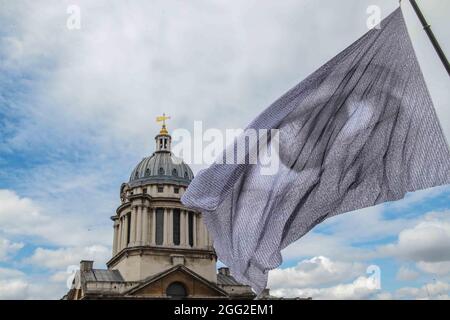 London UK 28. August 2021 im Rahmen des Greenwich & Docklands International Festival ist Dan Achers We Are Watching ein auffallendes Bild eines riesigen Auges, das auf einer monumentalen Flagge geflogen ist, bestehend aus tausenden digitalen Porträts, Beigetragen von Menschen aus 190 Ländern weltweit.die 10-stöckige Hochflagge soll eine klare Botschaft an die Staats- und Regierungschefs der Welt senden, die die Macht haben, Entscheidungen über den Klimawandel zu beeinflussen: Dass die Augen der Welt auf sie gerichtet sind. Wir beobachten, wie Greenwich vom 27. Bis 30. August vor der geplanten COP26 im Laufe dieses Jahres in Glasgow überflogen wird.Paul Quezada-Neiman/Alamy Stockfoto