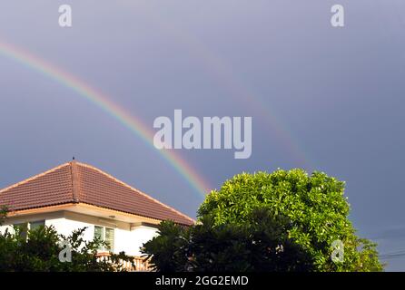 Großer Regenbogen über dem Dach Stockfoto