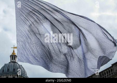 London UK 28. August 2021 im Rahmen des Greenwich & Docklands International Festival Dan Achers „We are watching“ ist ein auffälliges Bild eines riesigen Auges, das auf einer monumentalen Flagge geflogen ist, bestehend aus tausenden digitalen Porträts, Beigetragen von Menschen aus 190 Ländern weltweit.die 10-stöckige Hochflagge soll eine klare Botschaft an die Staats- und Regierungschefs der Welt senden, die die Macht haben, Entscheidungen über den Klimawandel zu beeinflussen: Dass die Augen der Welt auf sie gerichtet sind. Wir beobachten, wie vom 27. Bis 30. August über Greenwich fliegen wird, vor der geplanten COP26 im Laufe dieses Jahres in Glasgow.Paul Quezada-Neiman/Alamy L Stockfoto