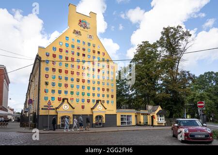 Riga, Lettland. 22. August 2021. Die Mauer eines Hauses mit der Darstellung der Wappen der Städte Lettlands im Zentrum der Stadt Stockfoto