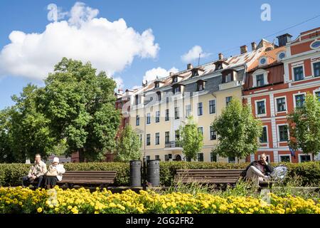 Riga, Lettland. 22. August 2021. Einige Leute sitzen auf den Bänken in einem Park im Zentrum der Stadt Stockfoto