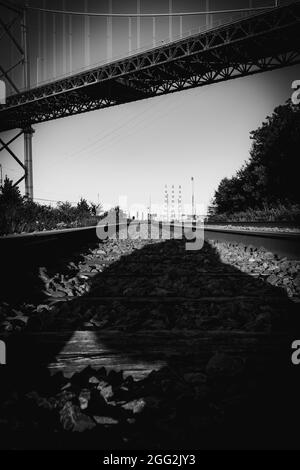 Schwarz-weißes Foto von Eisenbahnschienen unter der Mackay Bridge in Nova scotia Stockfoto