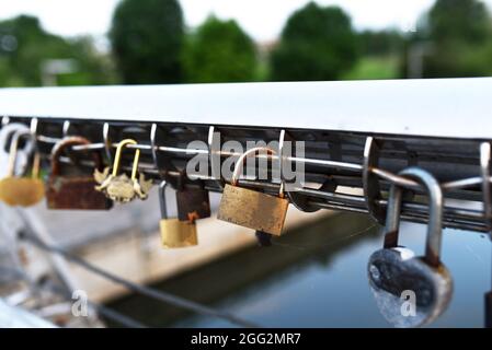 Vorhängeschloss auf Lovers Lock Bridge. Ehemann und Ehefrau hängten während der Hochzeit ein Vorhängeschloss an den Zaun auf ein Metallgitter. Love Locks Konzept. Viele ein Vorhängeschloss sind Stockfoto