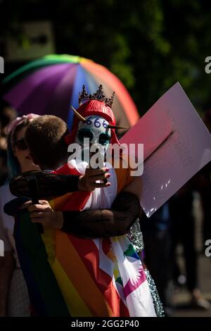 Manchester, Großbritannien. August 2021. Zwei Demonstranten umarmen sich vor dem Beginn eines Pride-Protestes. Hunderte von Menschen marschieren durch die Stadt, um gegen Manchester Pride Ltd zu protestieren.die Demonstranten fordern eine verbesserte Finanzierung für die LGBTQIA-Wohltätigkeitsorganisationen und Gemeindegruppen von Manchester. Kredit: Andy Barton/Alamy Live Nachrichten Stockfoto