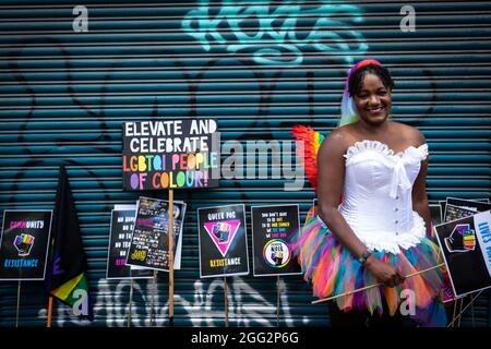 Manchester, Großbritannien. August 2021. Ein Protestler mit Plakaten wartet auf den Beginn des Pride-Protestes. Hunderte von Menschen marschieren durch die Stadt, um gegen Manchester Pride Ltd zu protestieren.die Demonstranten fordern eine verbesserte Finanzierung für die LGBTQIA-Wohltätigkeitsorganisationen und Gemeindegruppen von Manchester. Kredit: Andy Barton/Alamy Live Nachrichten Stockfoto