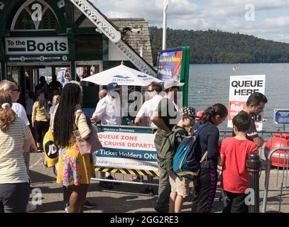 Lake Windermere .Cumbria . 28. August 2021 UK Wetter .Touristen, die das Wochenend-Wetter der Bankfeiertage für Bootsausflüge, Essen im Freien und Heiraten optimal ausgenießen Mr & Mrs Andrew & Levie Lee, die in der Kneipe Schlange stehen. Kredit: Gordon Shoosmith/Alamy Live Nachrichten Stockfoto