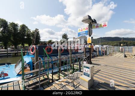 Lake Windermere .Cumbria . 28. August 2021 UK Wetter .Touristen, die das Wochenend-Wetter der Bankfeiertage für Bootsausflüge, Essen im Freien und Heiraten optimal ausgenießen Mr & Mrs Andrew & Levie Lee, die in der Kneipe Schlange stehen. Kredit: Gordon Shoosmith/Alamy Live Nachrichten Stockfoto