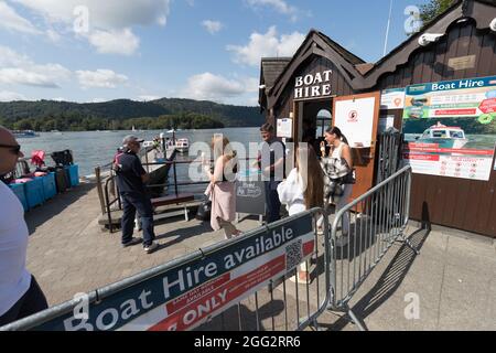 Lake Windermere .Cumbria . 28. August 2021 UK Wetter .Touristen, die das Wochenend-Wetter der Bankfeiertage für Bootsausflüge, Essen im Freien und Heiraten optimal ausgenießen Mr & Mrs Andrew & Levie Lee, die in der Kneipe Schlange stehen. Kredit: Gordon Shoosmith/Alamy Live Nachrichten Stockfoto