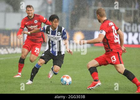 Bielefeld, Deutschland. August 2021. Fußball: Bundesliga, Arminia Bielefeld - Eintracht Frankfurt, Matchday 3 in der Schüco Arena. Bielefelds Masaya Okugawa (M) kämpft mit dem Frankfurter Martin Hinteregger (r) um den Ball. Kredit: Friso Gentsch/dpa - WICHTIGER HINWEIS: Gemäß den Bestimmungen der DFL Deutsche Fußball Liga und/oder des DFB Deutscher Fußball-Bund ist es untersagt, im Stadion und/oder vom Spiel aufgenommene Fotos in Form von Sequenzbildern und/oder videoähnlichen Fotoserien zu verwenden oder zu verwenden./dpa/Alamy Live News Stockfoto