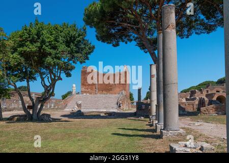 Das capitolium bei archäologischen Ausgrabungen von Ostia Antica von Ruinen, Säulen und Statuen und Reliefs umgeben Stockfoto