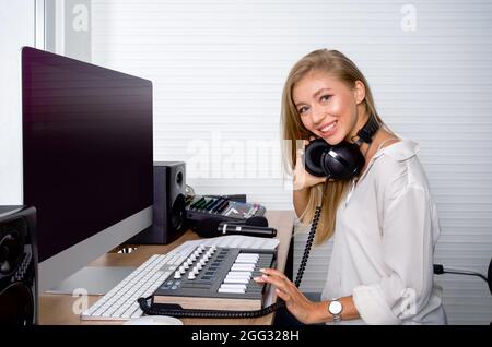 Der Toningenieur überprüft vor Beginn der Arbeiten die Richtigkeit des Audiorecorders. Atmosphäre produziert Musik in einem professionellen Aufnahmestudio. Stockfoto