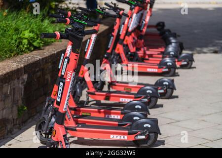 BRISTOL, Großbritannien - 19. AUGUST 2021: Reihen von VOI. Elektroroller, die tagsüber auf einer Straße in Bristol geparkt sind Stockfoto