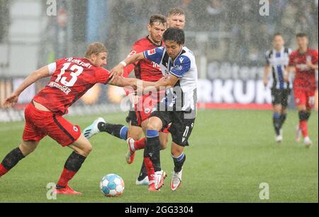 Bielefeld, Deutschland. August 2021. Fußball: Bundesliga, Arminia Bielefeld - Eintracht Frankfurt, Matchday 3 in der Schüco Arena. Bielefelds Masaya Okugawa (r) kämpft mit dem Frankfurter Martin Hinteregger (l) um den Ball. Kredit: Friso Gentsch/dpa - WICHTIGER HINWEIS: Gemäß den Bestimmungen der DFL Deutsche Fußball Liga und/oder des DFB Deutscher Fußball-Bund ist es untersagt, im Stadion und/oder vom Spiel aufgenommene Fotos in Form von Sequenzbildern und/oder videoähnlichen Fotoserien zu verwenden oder zu verwenden./dpa/Alamy Live News Stockfoto