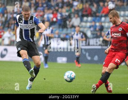 Bielefeld, Deutschland. August 2021. Fußball: Bundesliga, Arminia Bielefeld - Eintracht Frankfurt, Matchday 3 in der Schüco Arena. Bielefelds Fabian Klos (l) kämpft mit dem Frankfurter Martin Hinteregger (r) um den Ball. Kredit: Friso Gentsch/dpa - WICHTIGER HINWEIS: Gemäß den Bestimmungen der DFL Deutsche Fußball Liga und/oder des DFB Deutscher Fußball-Bund ist es untersagt, im Stadion und/oder vom Spiel aufgenommene Fotos in Form von Sequenzbildern und/oder videoähnlichen Fotoserien zu verwenden oder zu verwenden./dpa/Alamy Live News Stockfoto