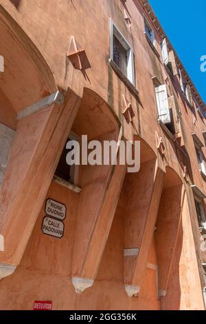Reihe von bunten bunten bunten Gebäuden auf der Hauptstraße Corso del Popolo in Chioggia historischen Zentrum, blauer Himmel Hintergrund im Sommer Tag, Stockfoto