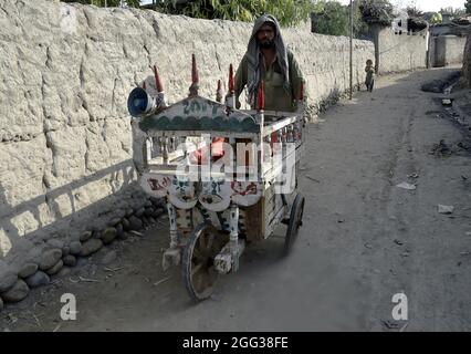 (210828) -- PESHAWAR, 28. August 2021 (Xinhua) -- EIN Mann verkauft am 28. August 2021 in einem Flüchtlingslager in Peshawar im Nordwesten Pakistans Eis. Pakistan beherbergt derzeit mehr als 1.4 Millionen registrierte afghanische Flüchtlinge, die aus ihrer Heimat fliehen mussten, so der hohe Flüchtlingskommissar der Vereinten Nationen (UNHCR). (Foto von Saeed Ahmad/Xinhua) Stockfoto