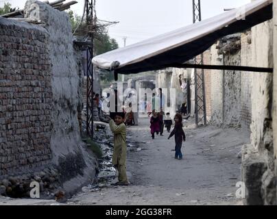 (210828) -- PESHAWAR, 28. August 2021 (Xinhua) -- afghanische Flüchtlingskinder spielen am 28. August 2021 in einem Flüchtlingslager im nordwestlichen Pakistans Peshawar. Pakistan beherbergt derzeit mehr als 1.4 Millionen registrierte afghanische Flüchtlinge, die aus ihrer Heimat fliehen mussten, so der hohe Flüchtlingskommissar der Vereinten Nationen (UNHCR). (Foto von Saeed Ahmad/Xinhua) Stockfoto