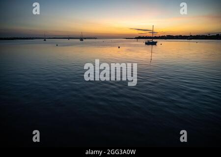 Segelboote beherbergen in Matanzas Bay bei Sonnenaufgang in St. Augustine, Florida, mit Vilano Beach, Matanzas Inlet und Anastasia Island in der Ferne. Stockfoto