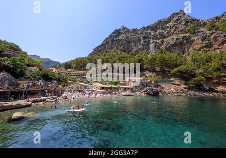 PORT DE SA CALOBRA, SPANIEN - 21. JULI: Am 21. Juli 2021 wird in Port de Sa Calobra, Spanien, am Strand ein Sonnenbad und Schwimmen angeboten. Stockfoto