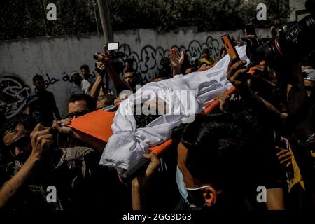 Gaza-Stadt, Gazastreifen, Palästina. August 2021. Gaza, Palästina. 28. August 2021. Eine große verstörte Menge verabschiedete Omar Hasan Abu al-Nil, 12, während seiner Beerdigungszeremonie. Omar starb am frühen Samstag an seinen Wunden, die durch israelische Schüsse verursacht wurden, während einer Demonstration im Al-Malika-Flüchtlingslager am 20. August anlässlich des 52. Jahrestages eines Brandanschlags auf die Al-Aqsa-Moschee in Jerusalem. Das Kind wurde in den Kopf geschlagen und starb trotz einer Notoperation, um sein Leben zu retten (Foto: © Ahmad Hasaballah/IMAGESLIVE via ZUMA Press Wire) Stockfoto