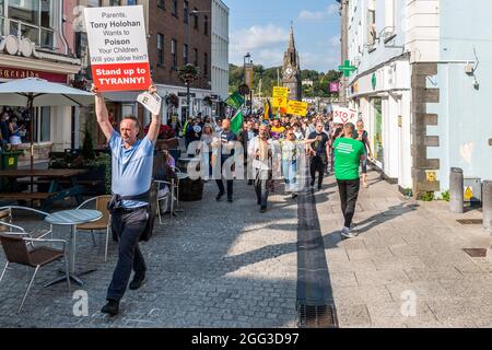 Waterford, Irland. August 2021. Rund 200 Menschen versammelten sich heute Nachmittag im Stadtzentrum von Waterford, um gegen die COVID-19-Impfstoffe zu protestieren, die ihrer Meinung nach experimentell sind und immer noch vor Gericht stehen. Die Demonstranten versammelten sich am Uhrenturm am Meagher's Quay und marschierten durch das Stadtzentrum. Quelle: AG News/Alamy Live News Stockfoto