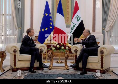 Bagdad, Irak. August 2021. Der irakische Präsident Barham Salih (R begrüßt den französischen Präsidenten Emmanuel Macron (L) am 28. August 2021 im irakischen Präsidentenpalast in Bagdad, Irak. Macron kam zu einem offiziellen Besuch in Bagdad an, bei dem er an einem Gipfel der Staats- und Regierungschefs des Nahen Ostens teilnehmen wird. Foto von der Pressestelle des irakischen Präsidenten/UPI Credit: UPI/Alamy Live News Stockfoto