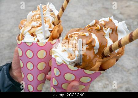 Nahaufnahme von zwei Bubble-Waffeln im Freien, Gofry Babelkowe, mit viel Eis in rosa Papiertüten. Berühmtes Dessert von Polen. Super süß Stockfoto