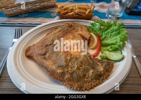 Nahaufnahme des gebratenen Steinbutts auf einem weißen Teller in der lokalen Kneipe Hel, Polen. Traditionelle polnische Meeresfrüchte. Stockfoto