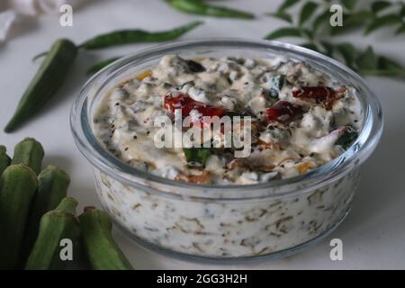 Ladies Finger raita oder Vendaka kichadi. Eine Beilage auf Joghurtbasis für traditionelle Kerala-Gerichte. Knusprig gebratene Ladies Finger in dickem und cremigem Joghurt. S Stockfoto