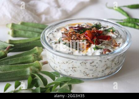 Ladies Finger raita oder Vendaka kichadi. Eine Beilage auf Joghurtbasis für traditionelle Kerala-Gerichte. Knusprig gebratene Ladies Finger in dickem und cremigem Joghurt. S Stockfoto