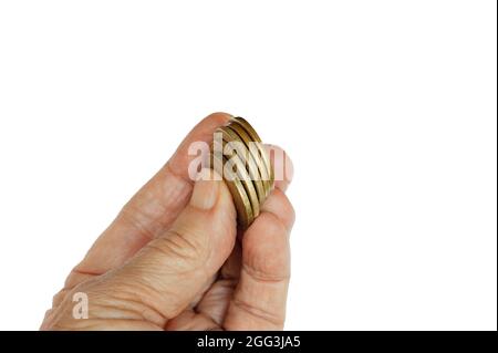 Goldmünzen, die von Fingern oder reifer Hand hochgehalten werden. Isoliert. Eine Gruppe von fünf Goldmünzen wird angehoben, um zu zeigen, zu geben, zu investieren. Stockfoto